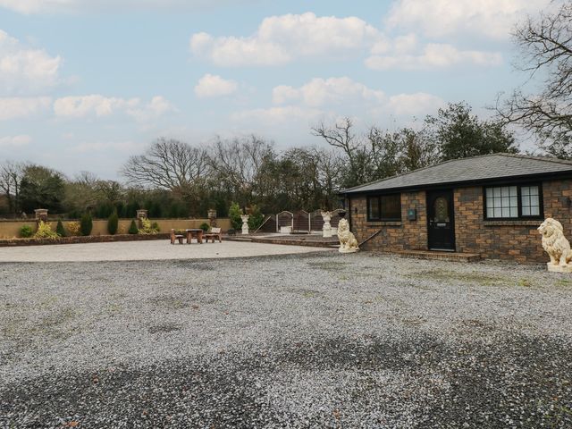 An outdoor area featuring a house, gravel driveway, and statues at Annexe @ Meadows Farm in Swansea
