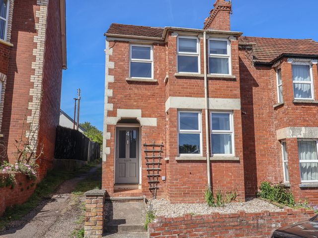 A brick house with windows and front door at 4 Peaslands Road in Sidmouth