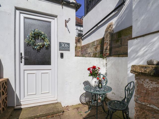 An outdoor seating area with a table and flowers at Marina House in Whitby