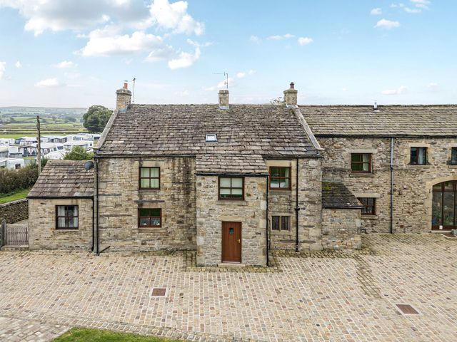 A stone house with a cobblestone pathway at Orcaber Farmhouse Lancaster