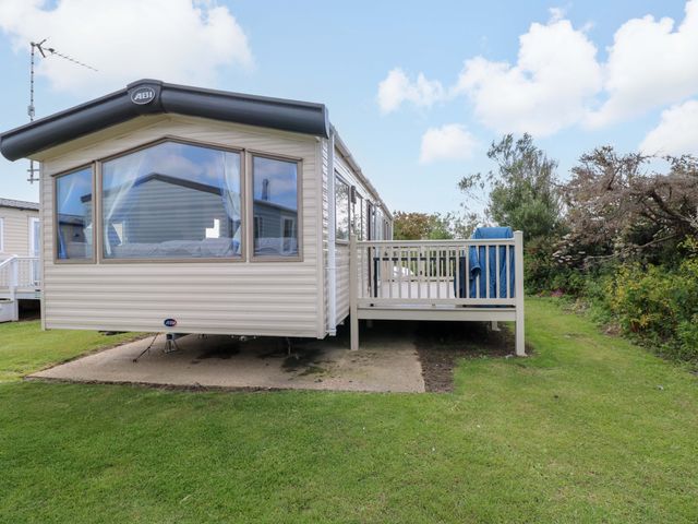 A static caravan with a deck in an outdoor area at PK Sunset View in Corton