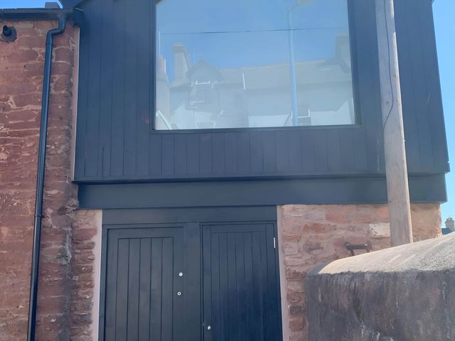 An exterior view of a building with doors and a window at Modern Seaside Cottage - Sleeps 5, Paignton