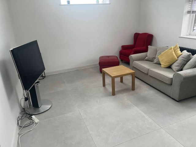 A living room with a television, sofa, armchair, and coffee table at Modern Seaside Cottage - Sleeps 5, Paignton