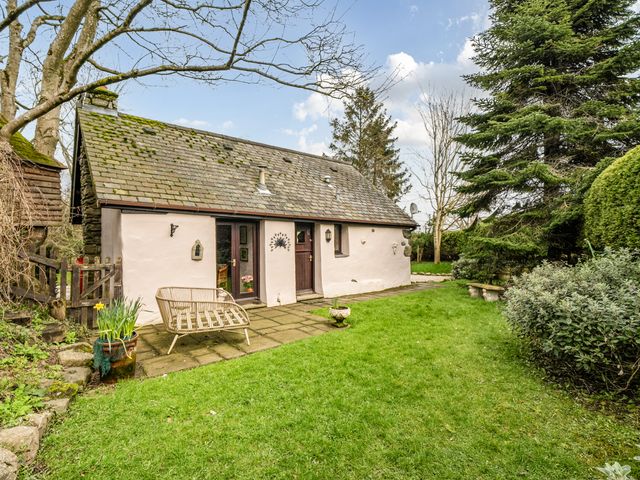 A garden with a house, pathway, and plants at Converted Stone Barn -20 Acres - Farm Animals! Corwen