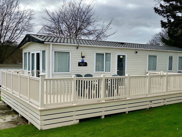 A static caravan with a deck and railing at Beautiful Static Caravan Hoburne Devon Bay