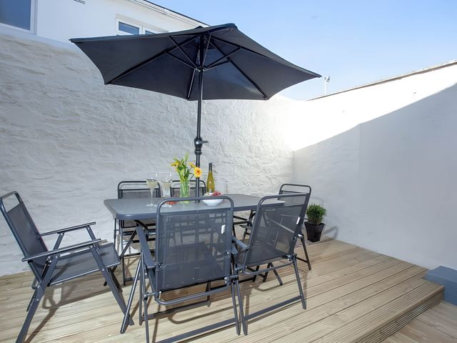 An outdoor dining area with a table and chairs at Torquay - House - Sleeps 6 - Pet Friendly