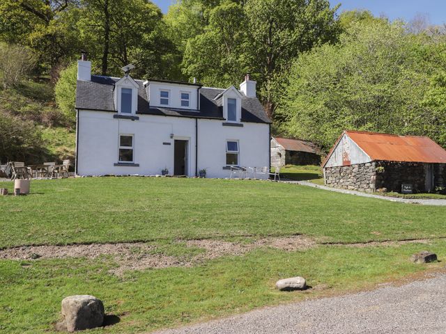 A house with outdoor furniture and a stone building at Tigh a Phailean in Letterfearn