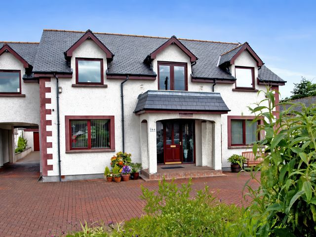 A house with a front door and flower pots at Dunhallin House in Inverness