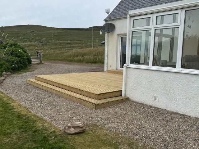 An outdoor area with wooden decking and gravel at An Grianan in Lairg