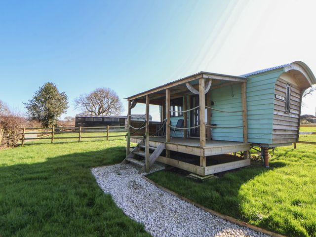 A cabin with steps and a grassy area at Golden Fleece in Biddulph Moor