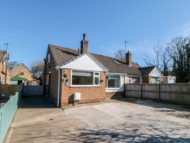 A house with a driveway and trees at Coastal Retreat in Scarborough