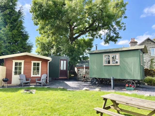 An outdoor area with a wooden cabin and a shepherd's hut at Cwt Tyddyn Shepherd's Hut Cefn Brith near Cerrigydrudion