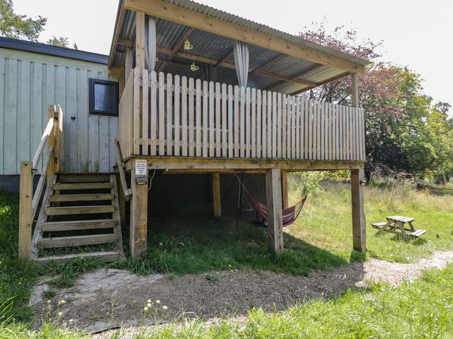 A wooden deck with steps and hammock at Robins Nest Lodge South Molton
