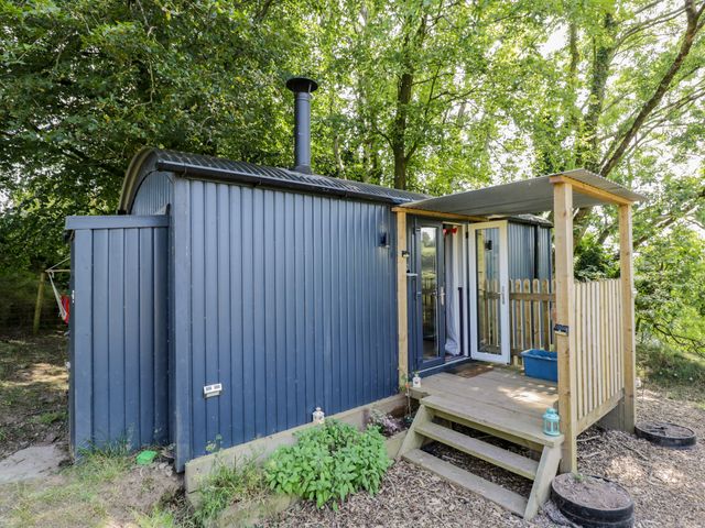 An outdoor view of a shepherd's hut with a deck at Valley View Shepherd's Hut in South Molton