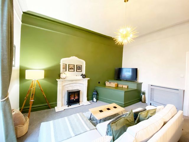 A living room with a sofa, coffee table, and television at 2B Redcliffe in Torquay