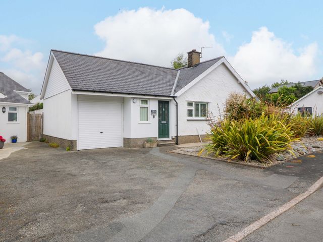 A house with a garage and plants at 5 Ger Afon Llanbedrog