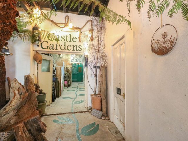 An entryway with a sign and door at Castle Gardens Apartment Beaumaris