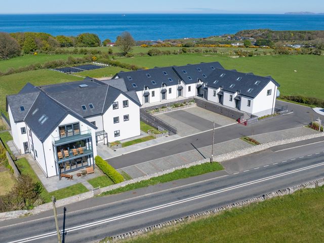 A residential building with a parking lot and ocean view at Glynllifon 5 in Marian-glas near Benllech