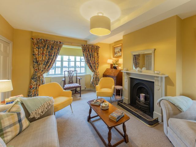 A living room with sofa and fireplace at Churchill Cottage in Bishop Auckland