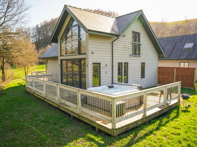 A house with a deck and hot tub at Oak Lodge in Llangunllo