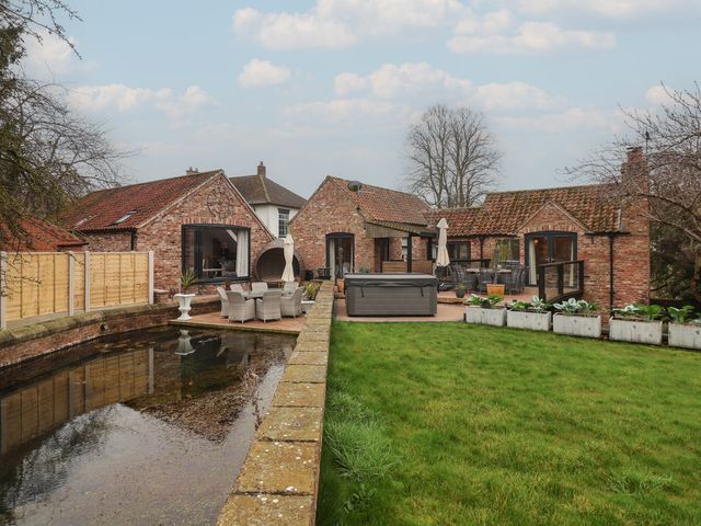 An outdoor area with houses and patio furniture at Mill Race Cottage in Driffield