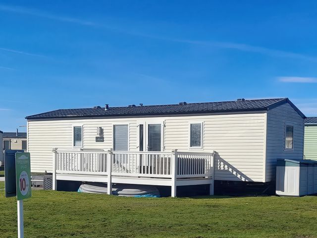 A mobile home with a deck and steps at 18 Fallows Fall in Leven