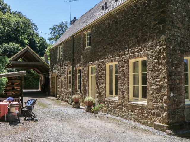 A stone house with outdoor furniture at Lukesland Wing in Ivybridge