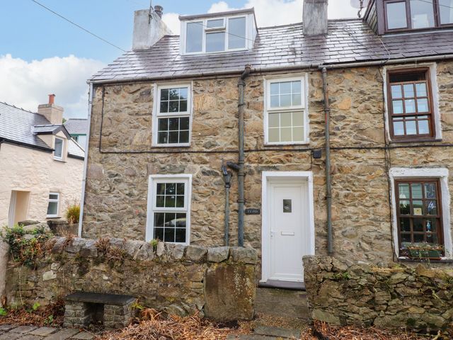A stone house with a door and windows at Ty Pen in Nefyn