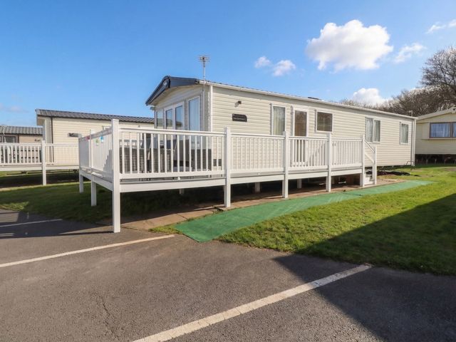 A mobile home with decking in a car park at Cresswell Towers 
