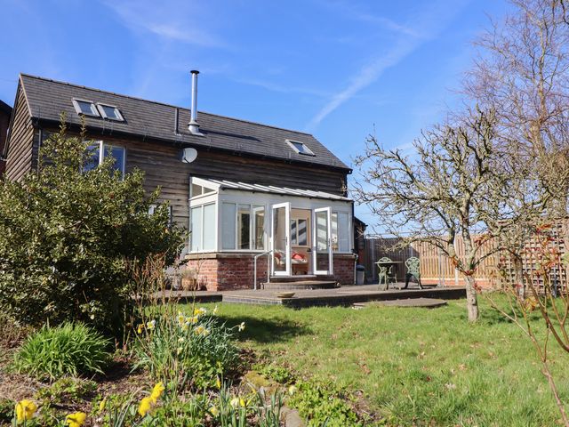 A house with a garden and deck at Ystwyth Cottage in Newtown