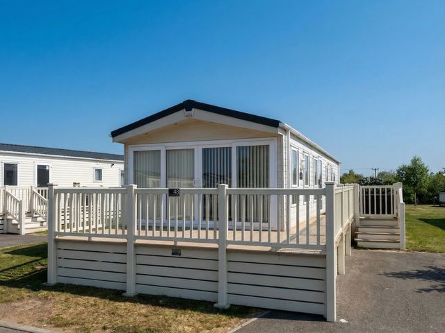 A caravan with a deck and steps at Tattershall Lakes Country Park - Holiday Accommodation 20875 Lincoln