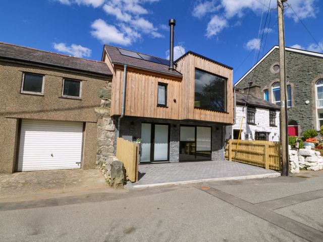A modern house with wooden features and a garage at Trwyn Cam Brynrefail near Llanberis