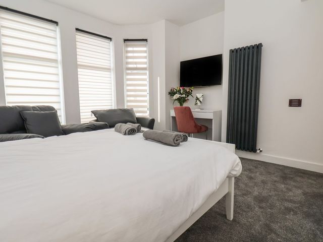 A bedroom with a bed and sofa at Frankie’s Seaview 4 in Bridlington