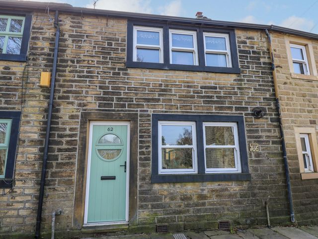 A stone exterior with windows and a front door at Milburn Cottage Keighley