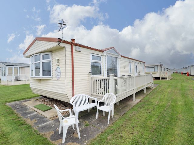 A caravan with decking and chairs at Towervans Z11 in Mablethorpe