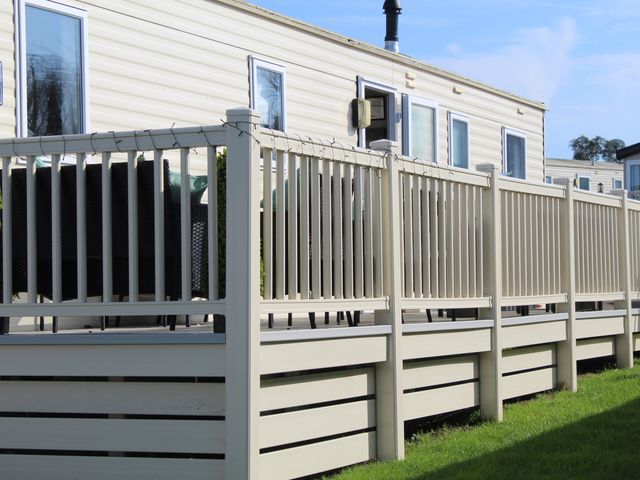 An outdoor area with a fence and seating at Kent Coast Holiday Park - Holiday Accommodation 22252, Rochester, Kent