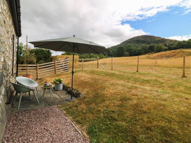 A patio with chairs and an umbrella at Little Oak near Tal-Y-Bont