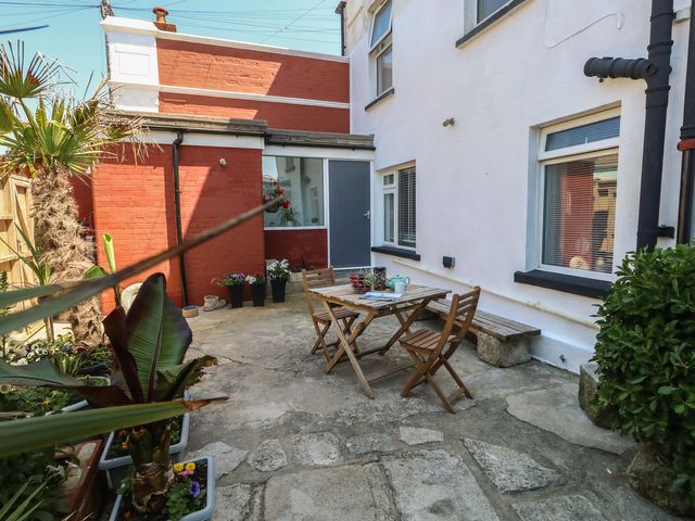 A garden with a table and chairs at Tipsy Turtle in Weymouth