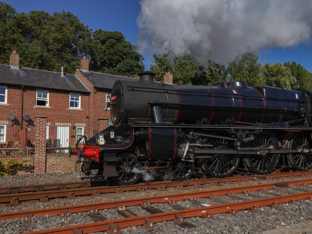 A steam locomotive beside brick buildings at Rails End in Whitby