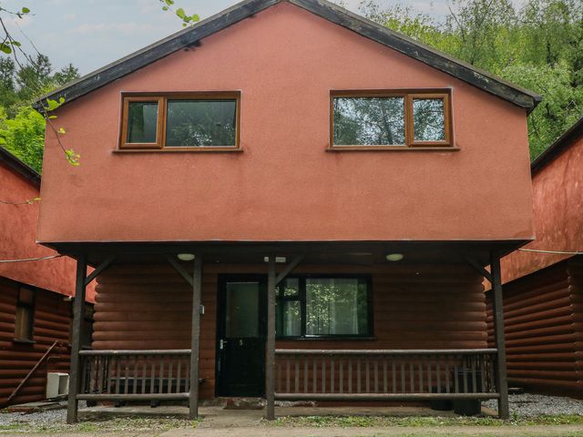 A cabin with large windows and a porch at Cabin No. 6 - Salt and Fern Cabins Goytre near Port Talbot