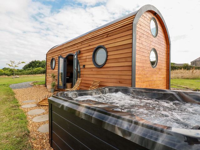 A wooden cabin with a hot tub in an outdoor area at The Olju in Truro