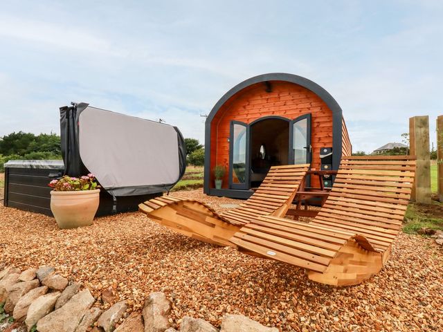 An outdoor space with a wooden cabin and hot tub at Stargaze Truro