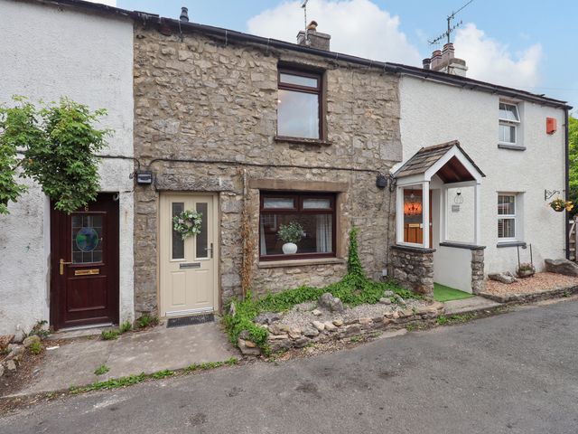 A stone building with front doors and windows at 7 Milnthorpe Road Holme near Burton-In-Kendal