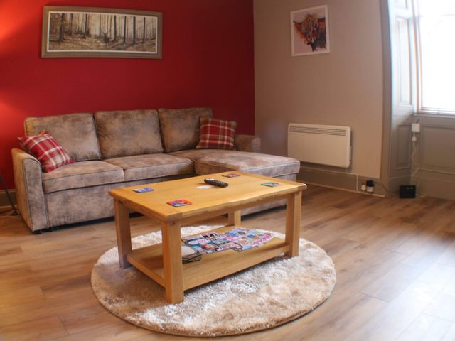 A living room with a sofa and coffee table at Stylish Highland retreat in the heart of town Pitlochry
