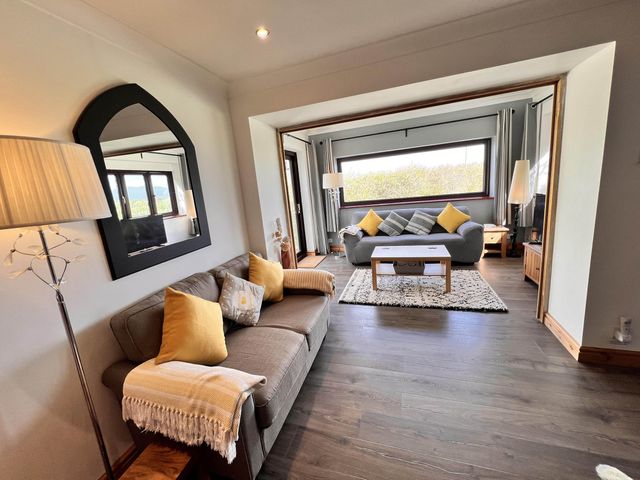 A living room with a sofa and coffee table at Cottage with mountain and sea views, Anglesey