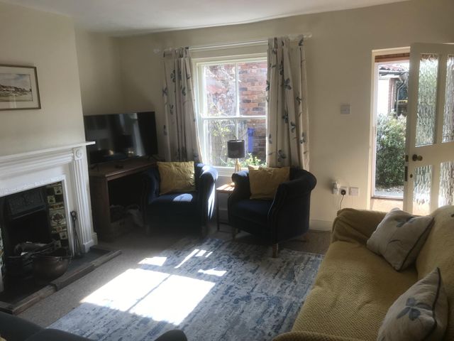 A living room with sofa and armchairs at tbc