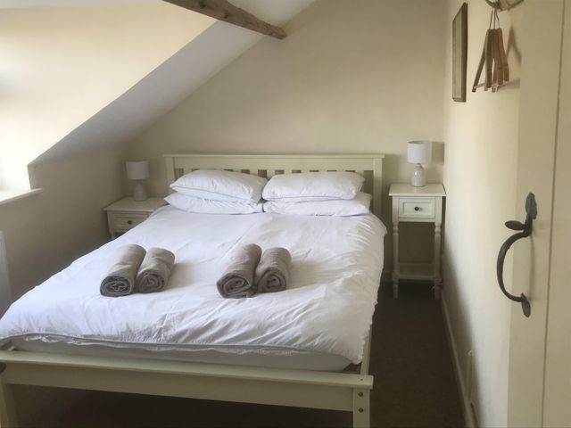 A bedroom with a bed and bedside tables at tbc
