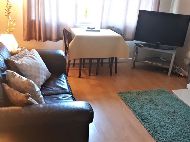 A living room with a sofa and a television at tbc 