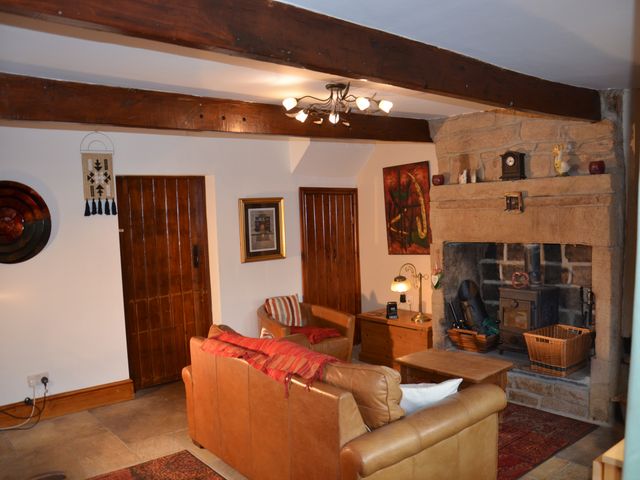 A living room with a fireplace and furniture at tbc