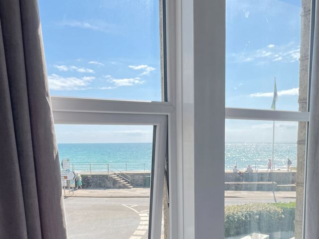 A view of the ocean and sky from a window at Seafront Soliel in Penzance